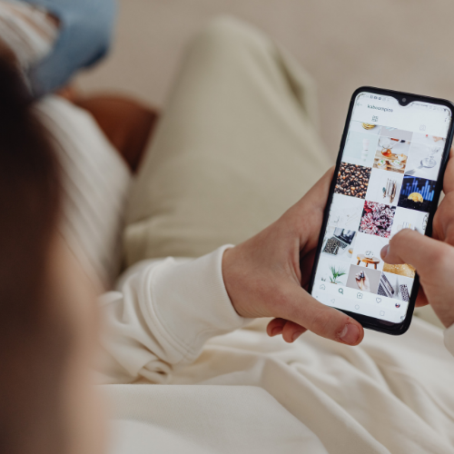 Mevrouw die op telefoon kijkt naar een instagram feed